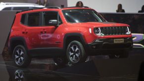 A red Jeep Renegade on display at an auto show