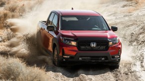 Honda Ridgeline in red on a dusty road. Honda Ridgeline vs. Passport is an interesting debate from a sales perspective