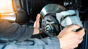 A mechanic putting brake calipers back on a car they're working on