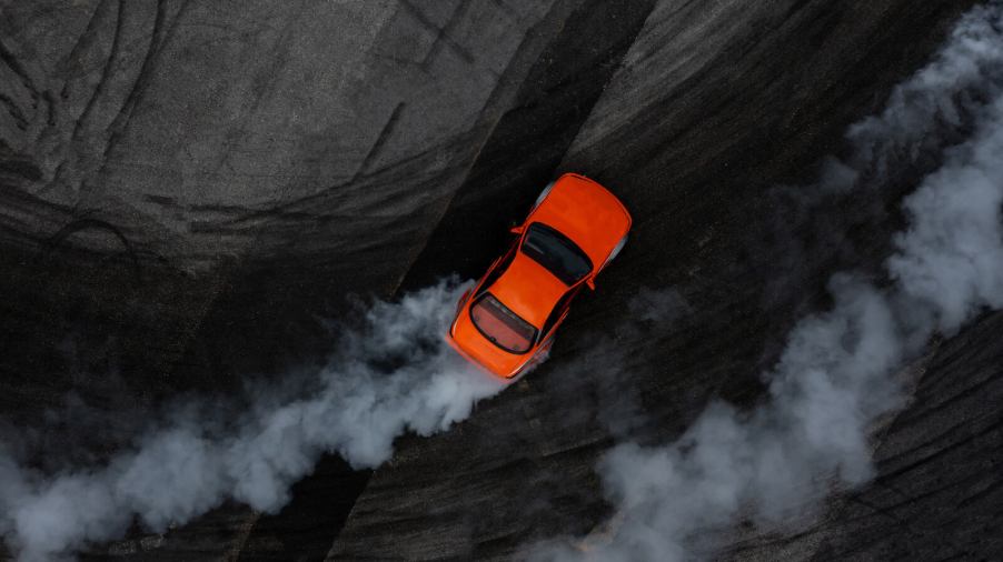 An aerial view of a red car drifting around a track corner