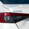 A white Honda Civic sedan in very close left rear view
